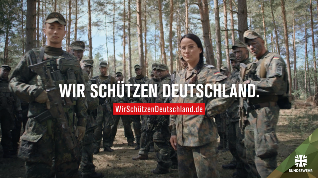 Soldaten der Bundeswehr stehen unter Bäumen. Dazu der Text "Wir schützen Deutschland."