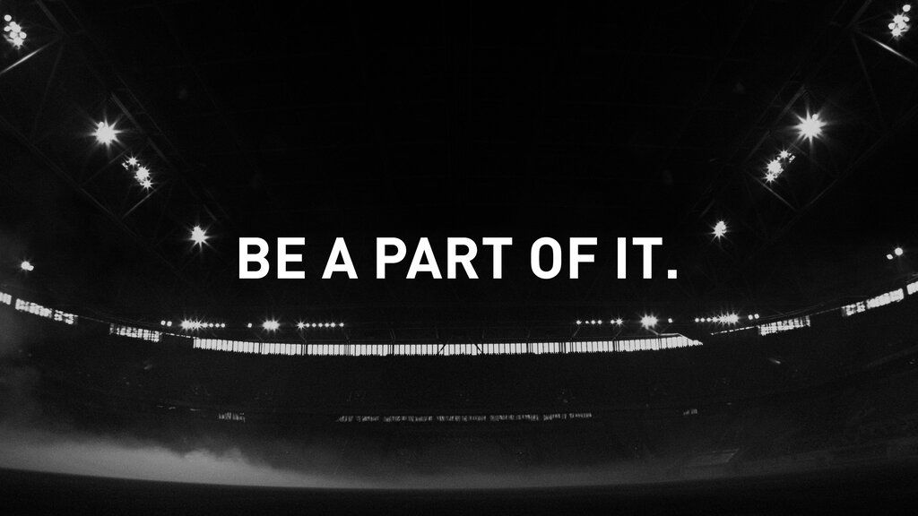 Ein Stadion im Dunkeln, darüber der Text "BE PART OF IT."
