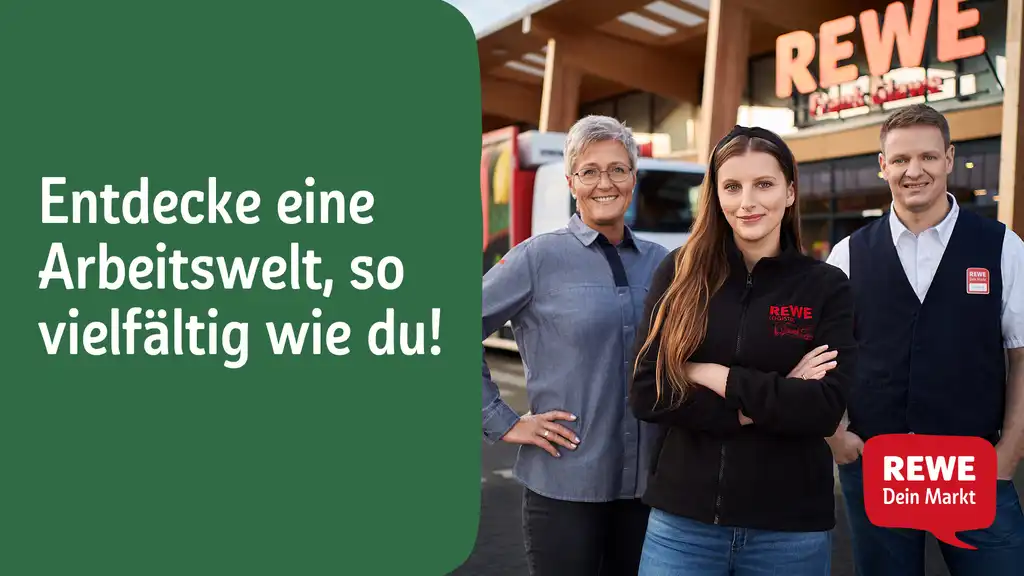 Drei REWE-Mitarbeiter stehen vor einer Filiale.