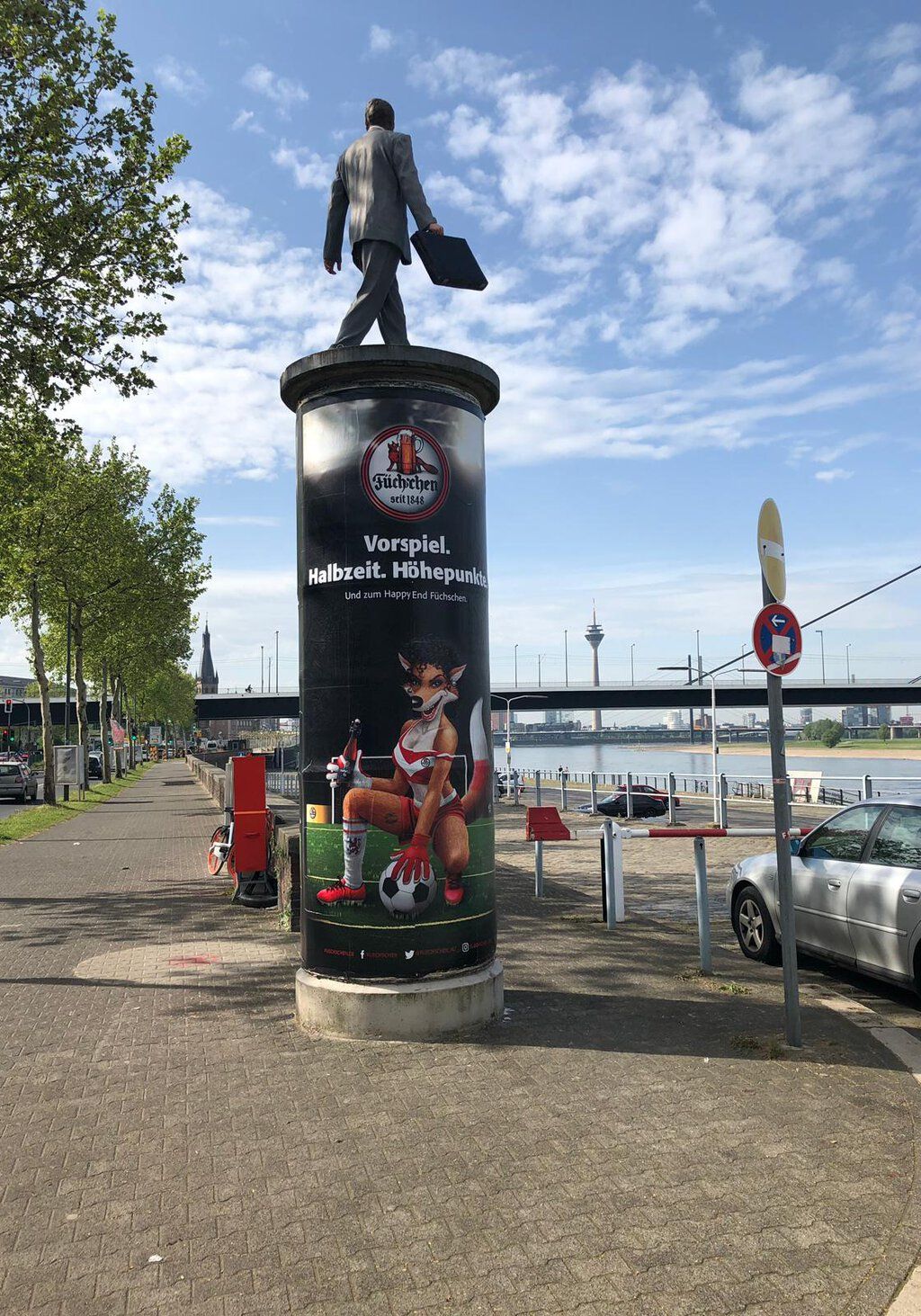 Werbeplakat der Brauerei Füchschen auf einer Litfaßsäule am Rheinufer in Düsseldor
