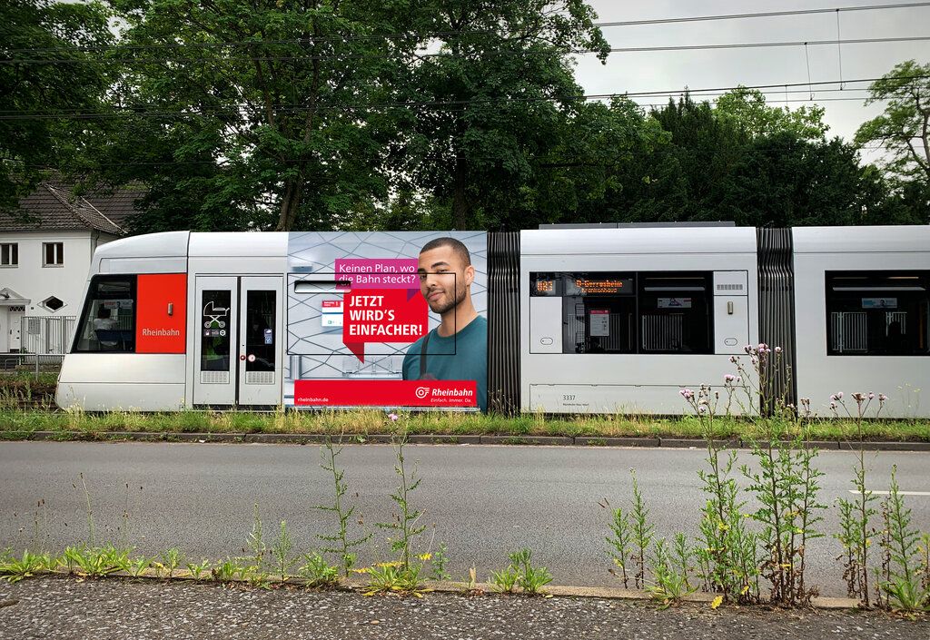Ein Werbeplakat der Rheinbahn auf der Seite einer Straßenbahn.