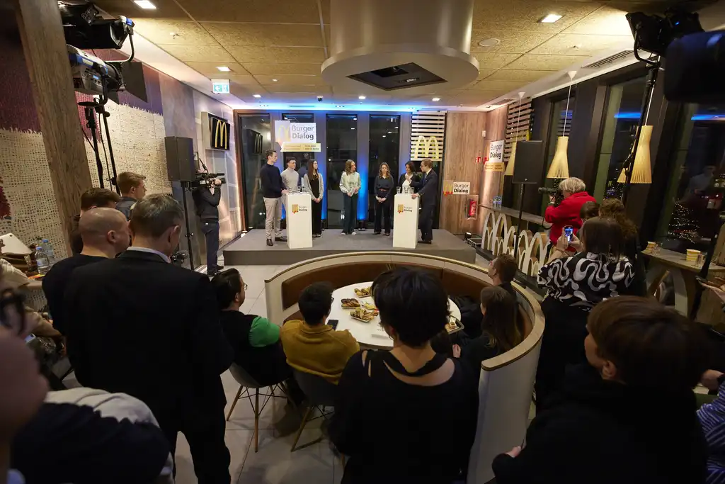 Der Blick auf die Bühne in einer McDonalds - Finale, auf der 6 Personen stehen und vor der mehrere Personen im Publikum stehen und sitzen.