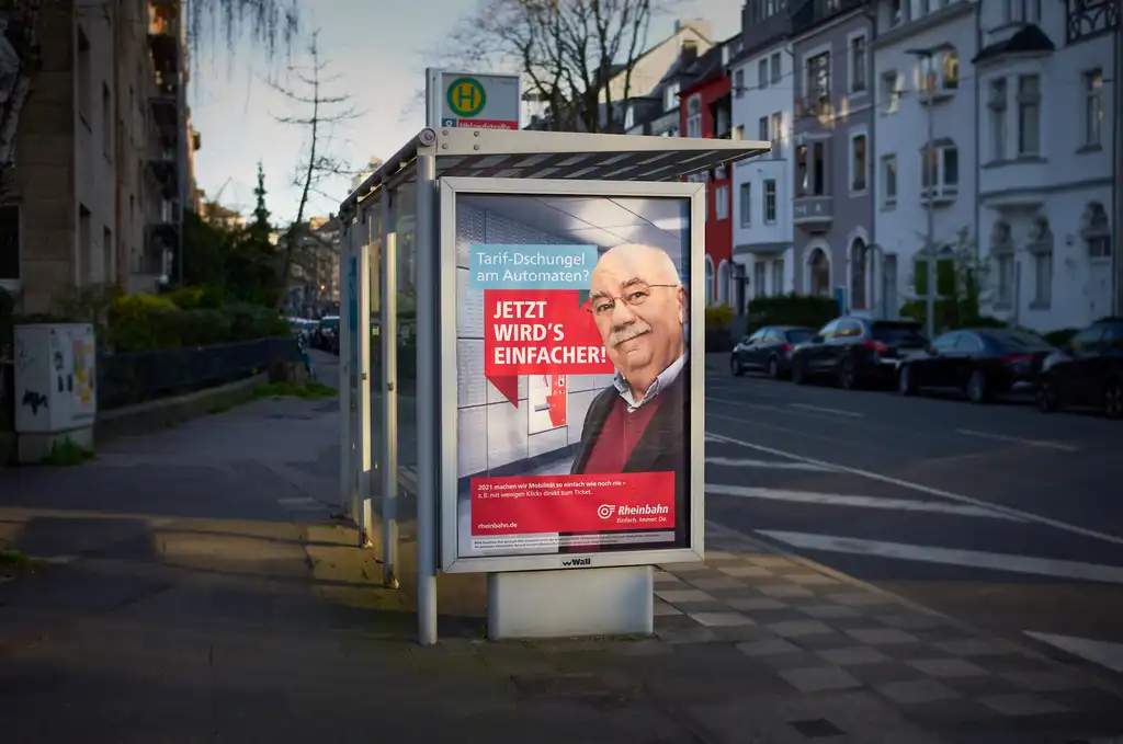 Ein Werbeplakat der Rheinbahn an einer Bushaltestelle.