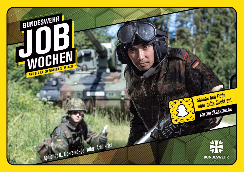 Zwei Soldaten der Artillerie im Einsatz, hinter ihnen ein Panzer.