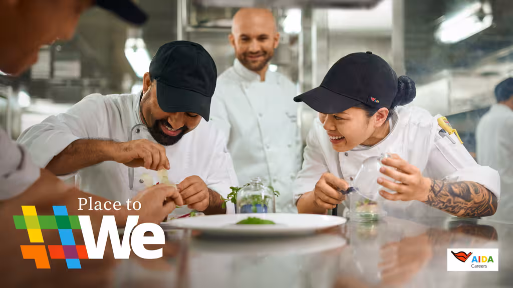 Zwei AIDA-Mitarbeiter bereiten in der Küche etwas zu, ein weiterer Mitarbeiter schaut ihnen dabei über die Schulter.