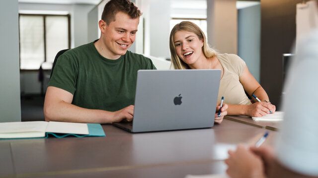 Mann und Frau schauen auf ein Laptop
