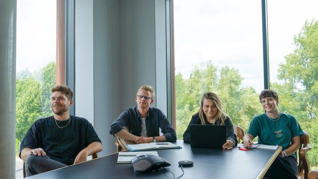 Mitarbeiter der Strategie der Castenow GmbH in Düsseldorf sitzen nebeneinander im Konferenzraum.