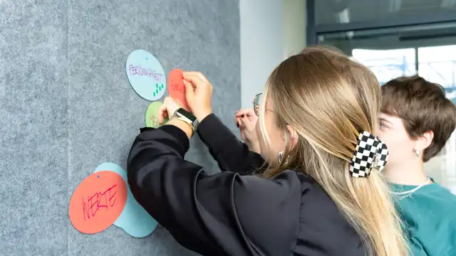 Mitarbeiter der Strategie der Castenow GmbH in Düsseldorf stehen vor einer Pinwand.