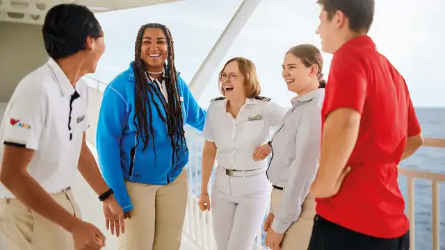 5 AIDA Mitarbeiter aus verschiedenen Bereichen stehen an der Reling eines Schiffes auf offenem Meer der Bundeswehr. 