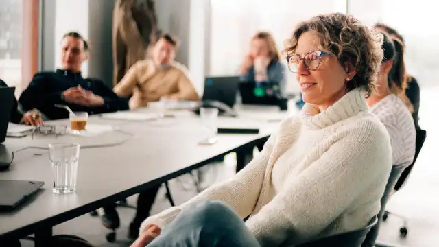 Sabine Castenow und andere Personen sitzen an einem Konferenztisch