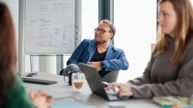 Jörg Wolf und Yvonne Bernshausen sitzen zusammen im Meeting