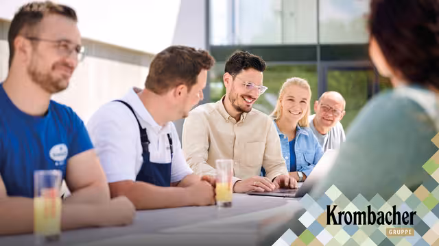 Mitarbeiter von Krombacher sitzen sich an einem Tisch gegenüber.
