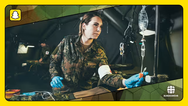 Eine Soldatin des Sanitätsdienst reguliert den Tropf eines Patienten.