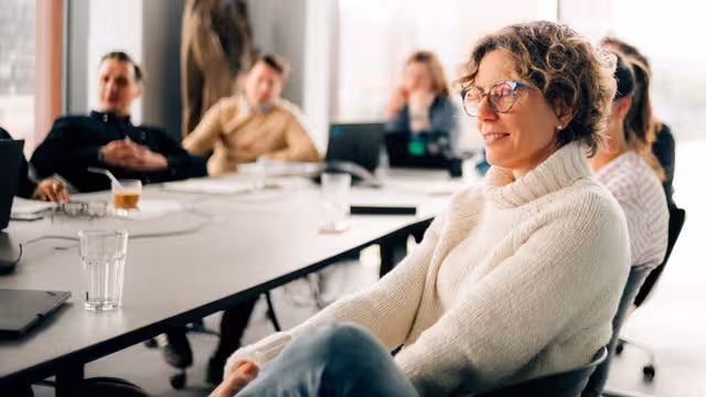 Sabine Castenow und andere Personen sitzen an einem Konferenztisch
