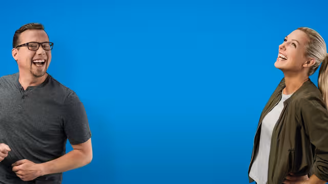 Zwei Mitarbeiter der Johanniter Unfall Hilfe lachen.