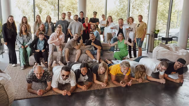 Die Mitarbeiter der Castenow GmbH feiern den Etat-Gewinn der Bundswehr.m an einer Outdoor-Terrasse.