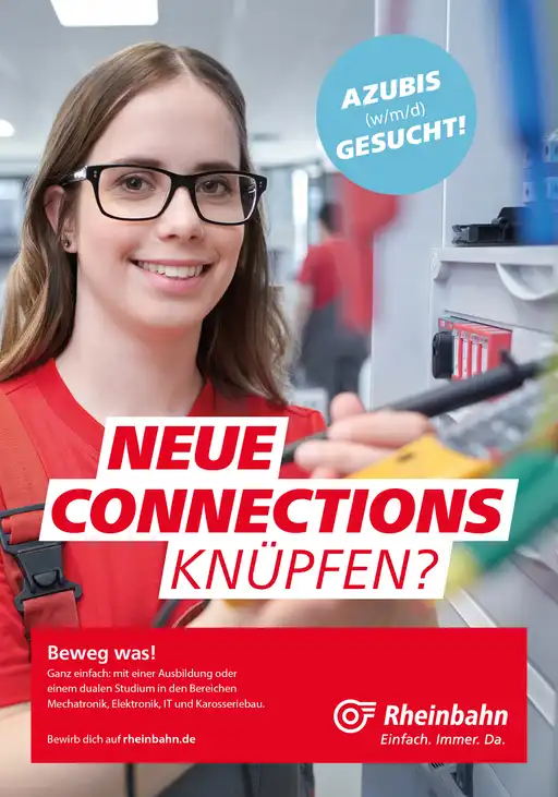 Eine junge Mitarbeiterin der Rheinbahn arbeitet an Computer-Technik und lacht in die Kamera.