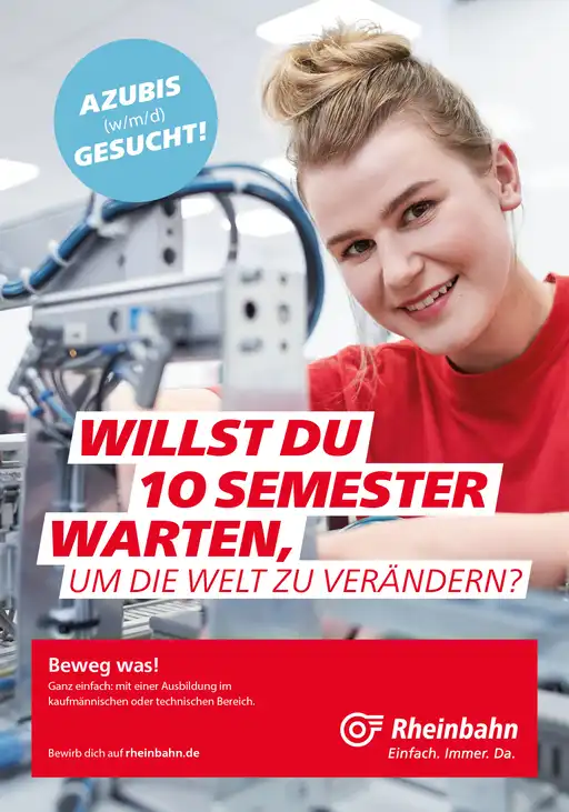 Eine junge Mitarbeiterin der Rheinbahn arbeitet an Computer-Technik und lacht in die Kamera.