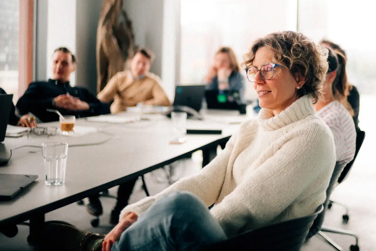Sabine Castenow und andere Personen sitzen an einem Konferenztisch