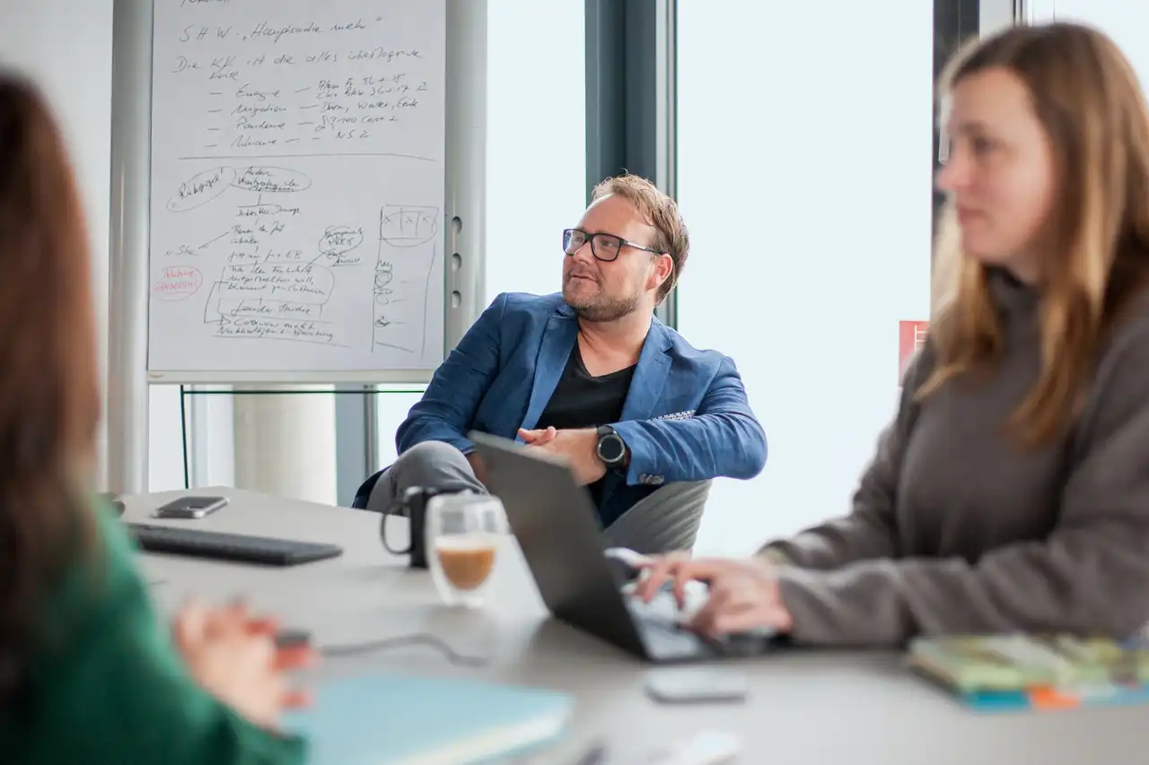 Mann und Frau sitzen an Besprechungstisch