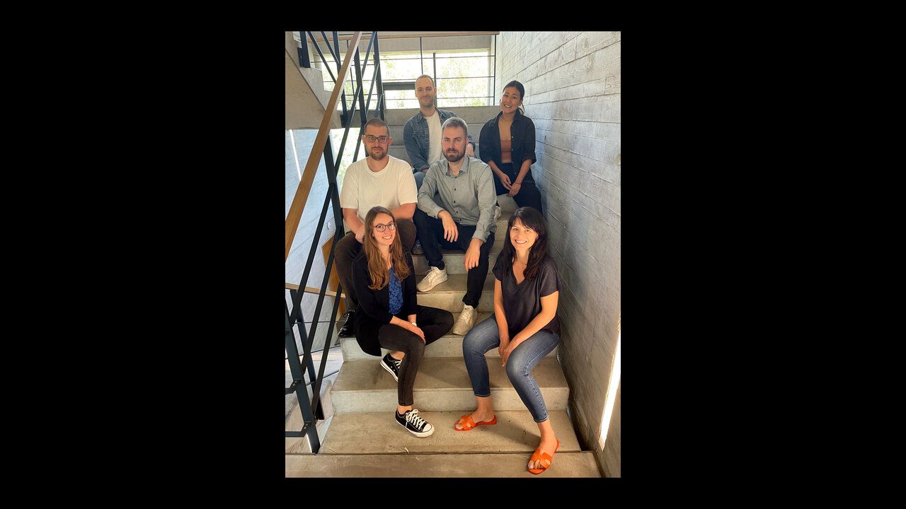 6 Mitarbeiter der Castenow GmbH sitzen auf den Stufen im Treppenhaus.