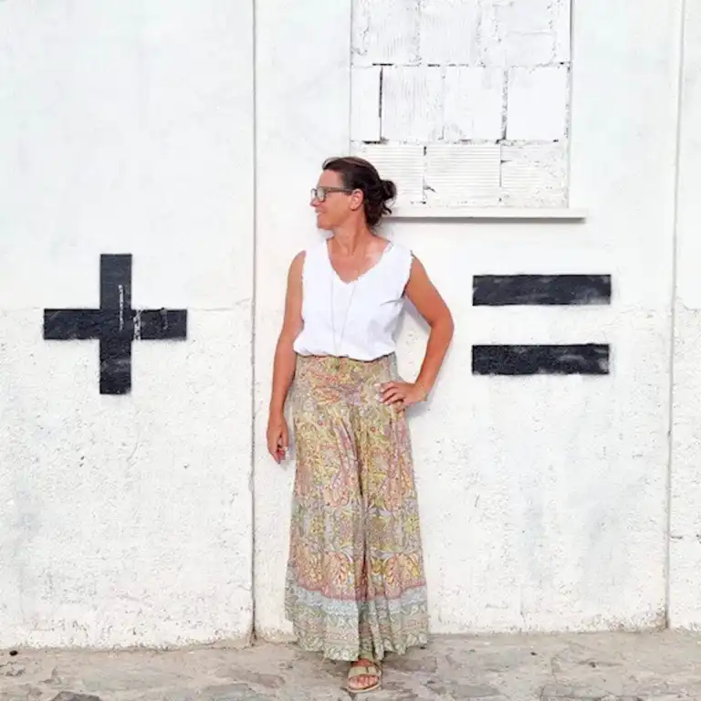 Steffi Daub, Mitarbeiterin von Castenow steht vor einer Wand, die mit + und - markiert ist.