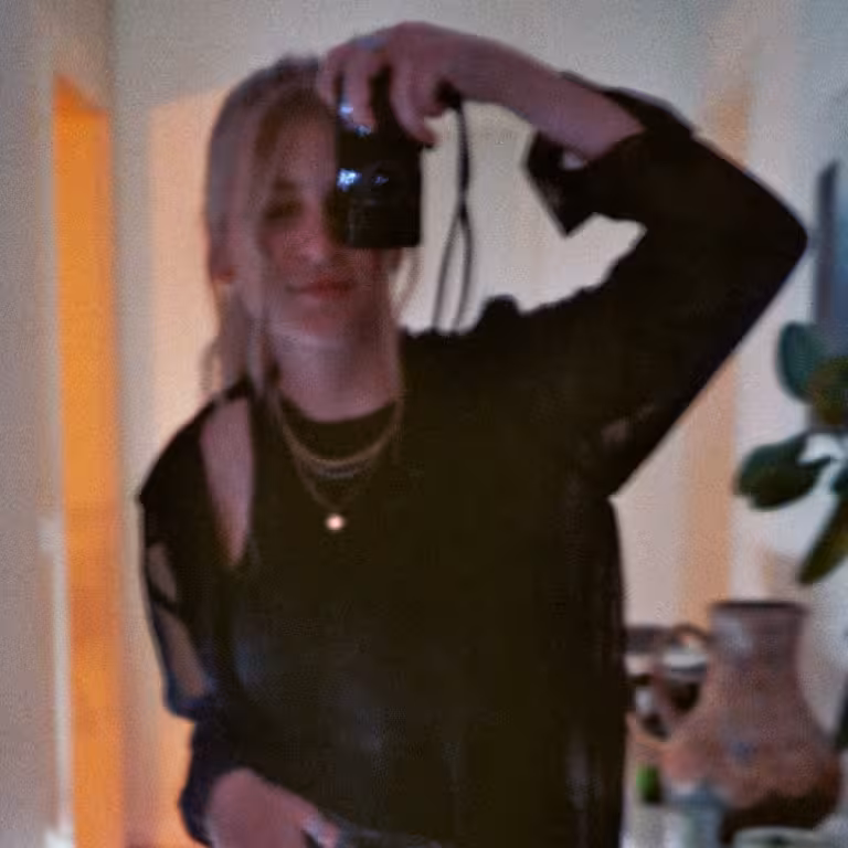 Nadja Ern, Mitarbeiterin der Castenow GmbH, steht im Flur einer Wohnung und fotografiert sich selbst im Spiegel.