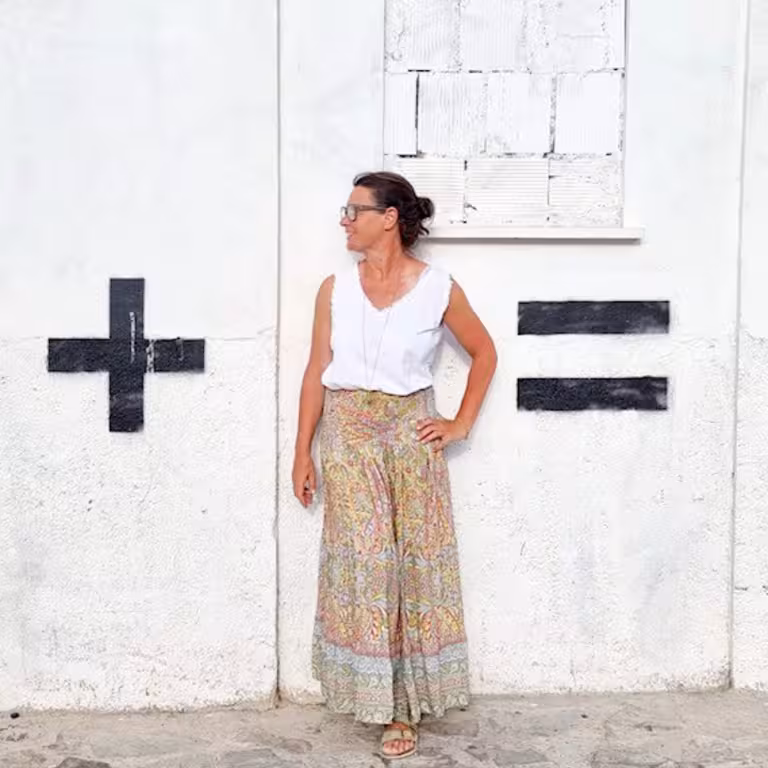 Steffi Daub, Mitarbeiterin von Castenow steht vor einer Wand, die mit + und - markiert ist.