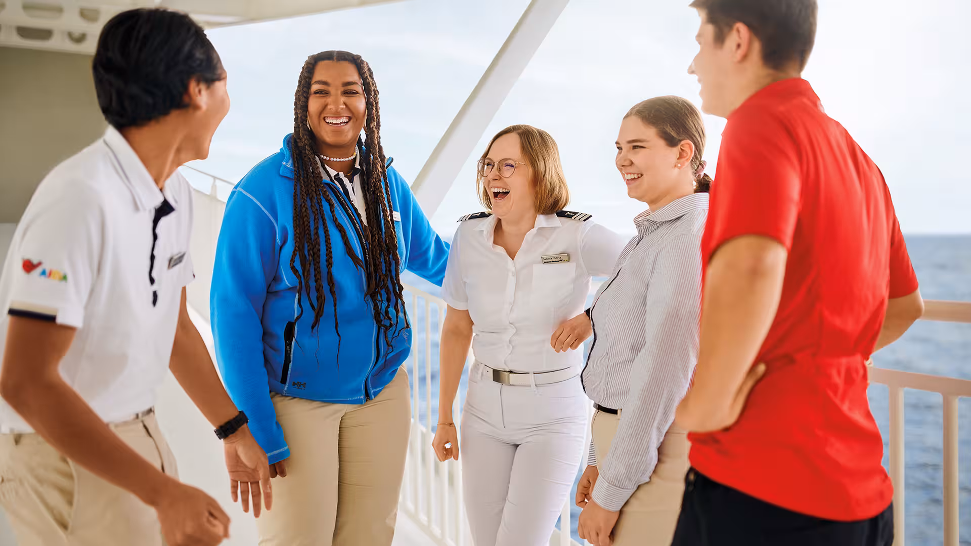 5 AIDA Mitarbeiter aus verschiedenen Bereichen stehen an der Reling eines Schiffes auf offenem Meer der Bundeswehr. 