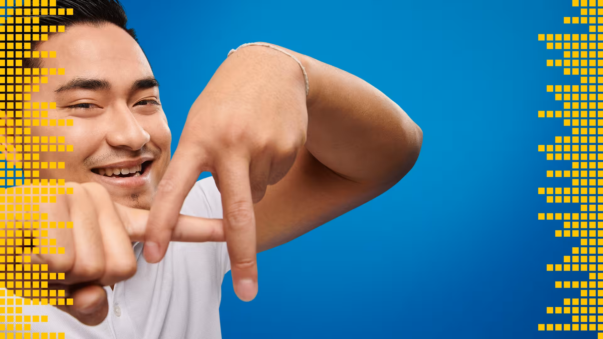 Ein dunkelhaariger junger Mitarbeiter von Arvato formt mit seinen Fingern ein A.