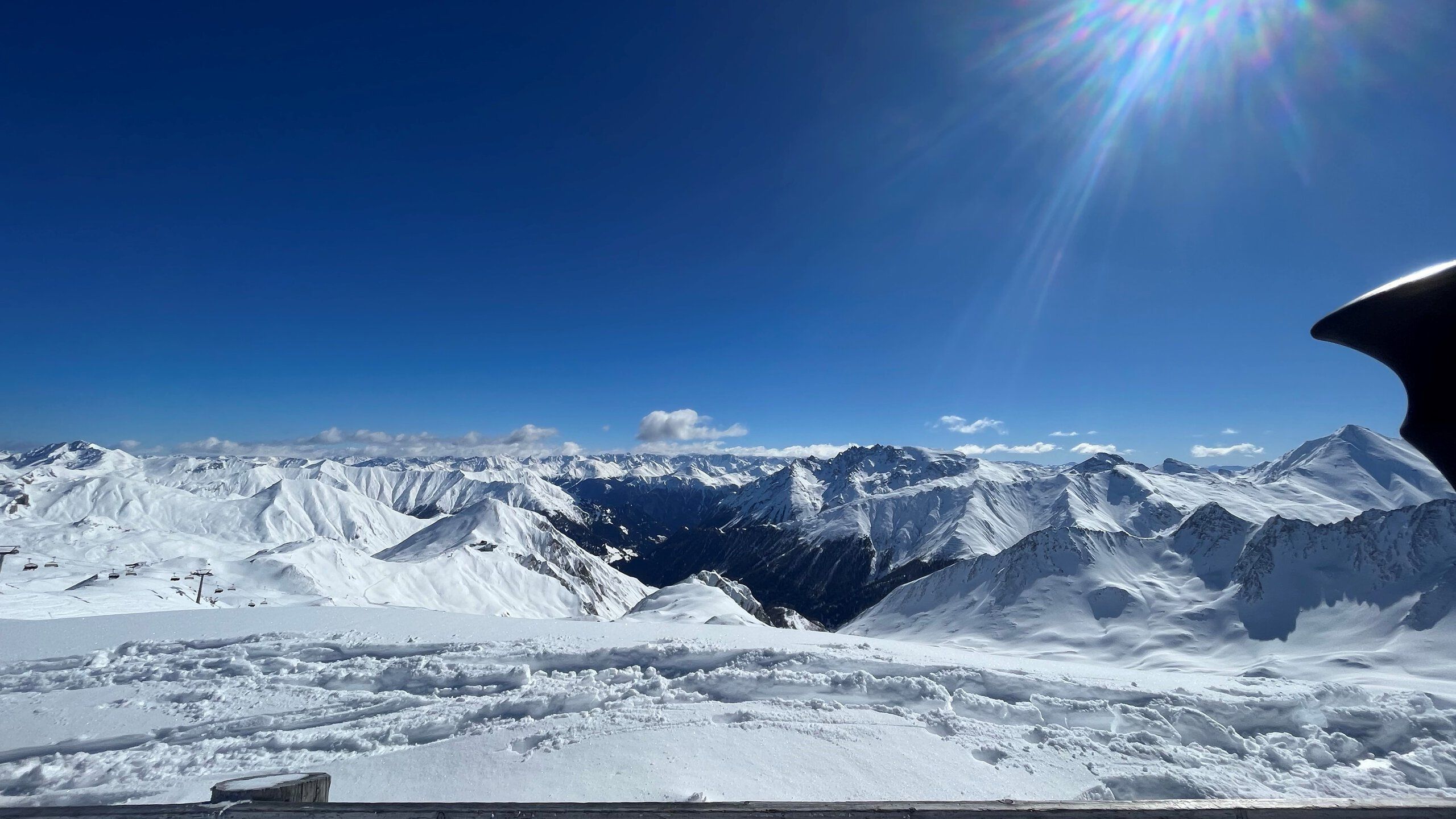 Ein Blick über schneebedeckte Bergspitzen unter blauem Himmel.