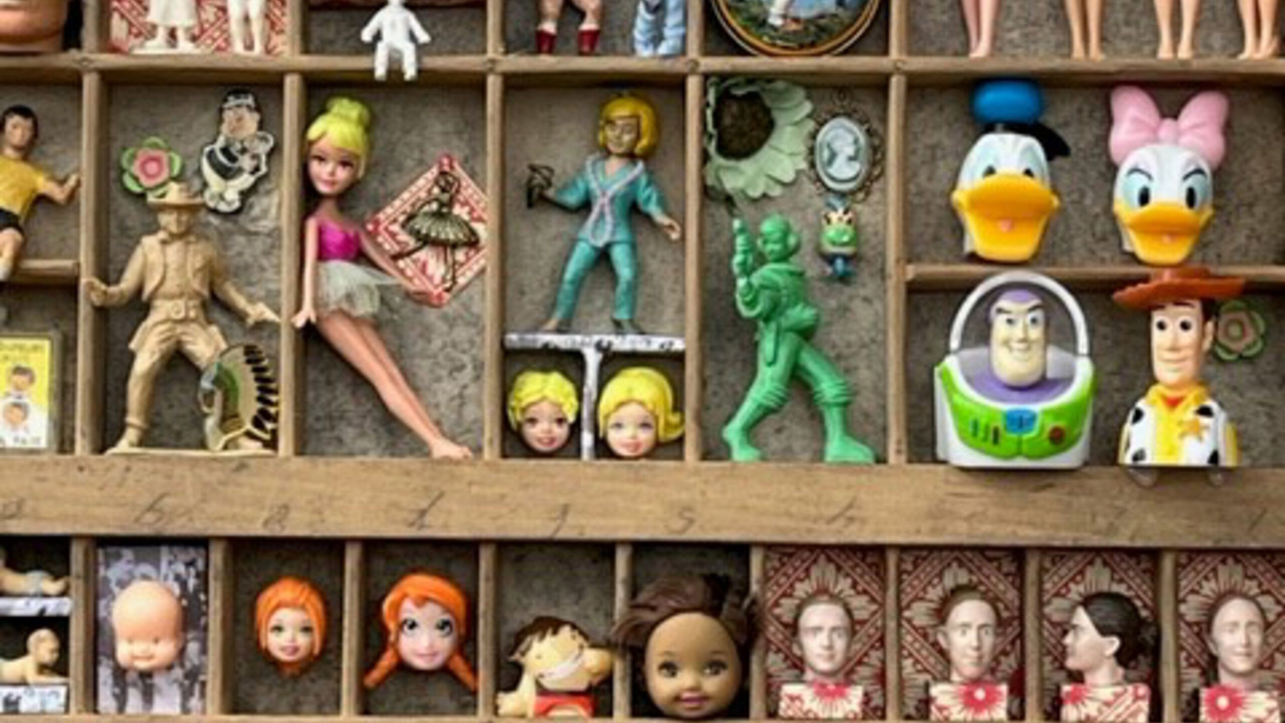 In einem Regal sind die Köpfe und Körper verschiedener Spielfiguren angeordnet.
