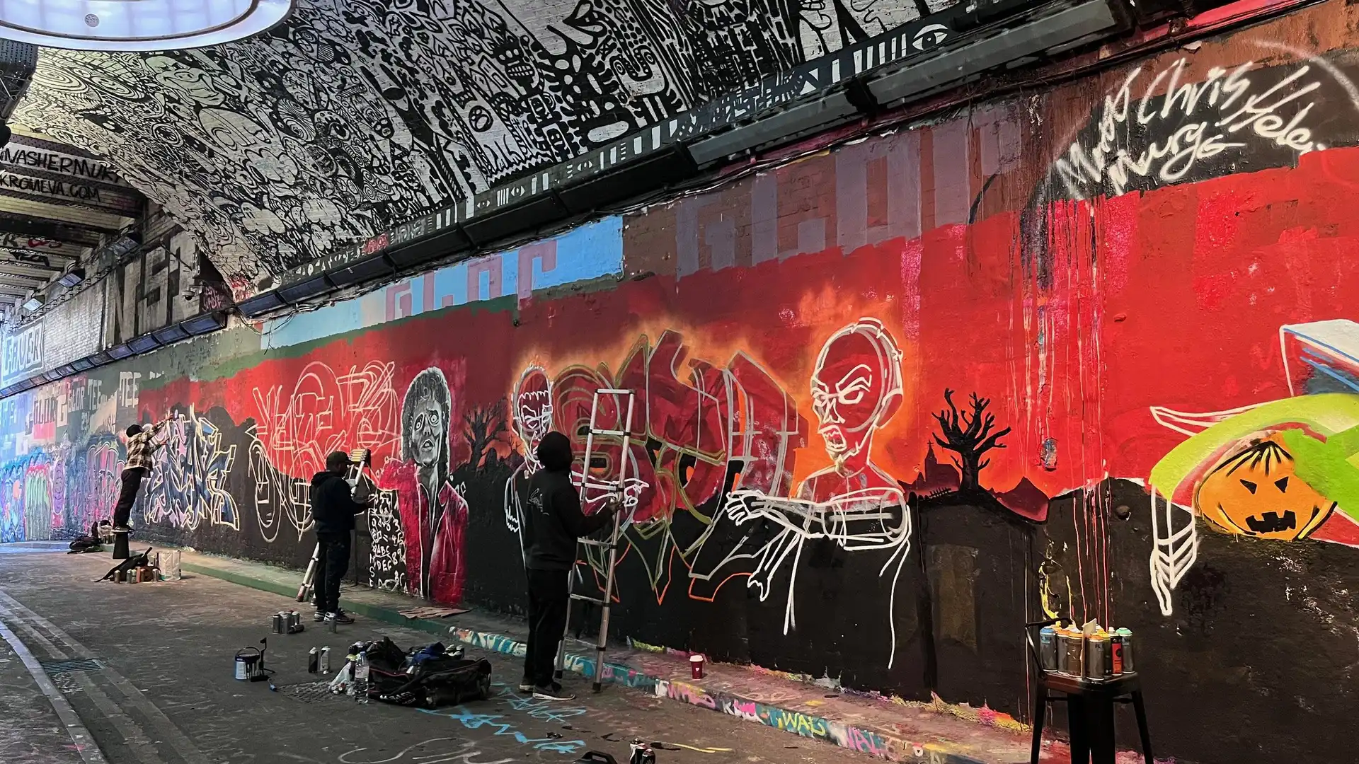 Ein Tunnel, in dem die Wand und die Decke von Graffiti-Künstlern bemalt wird.