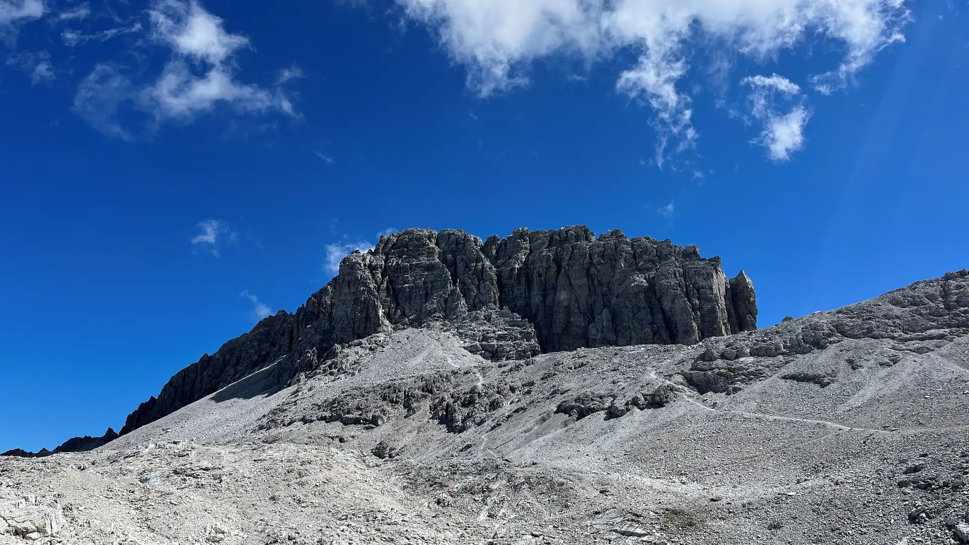 Ein Gebirge von unten fotografiert vor blauem Himmel.