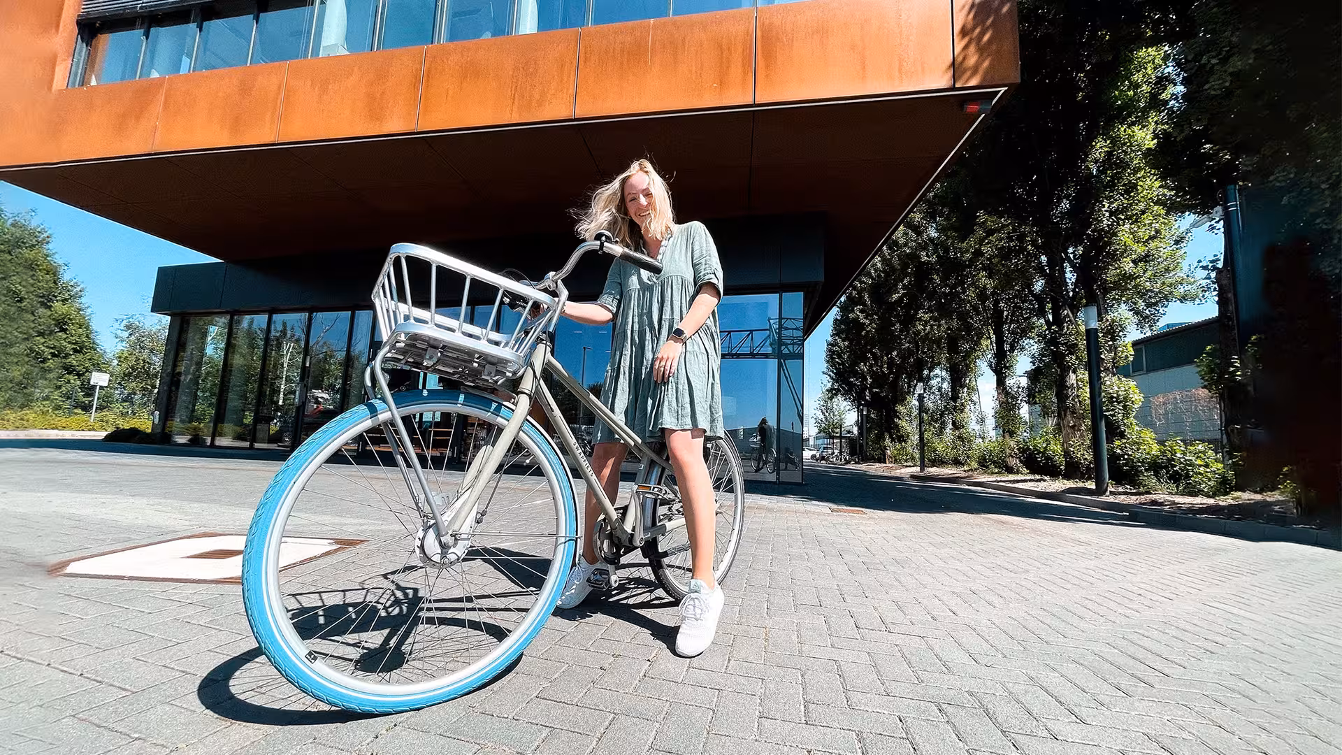 Eine Mitarbeiter von Castenow mit dem Fahrrad vor dem Agenturgebäude..