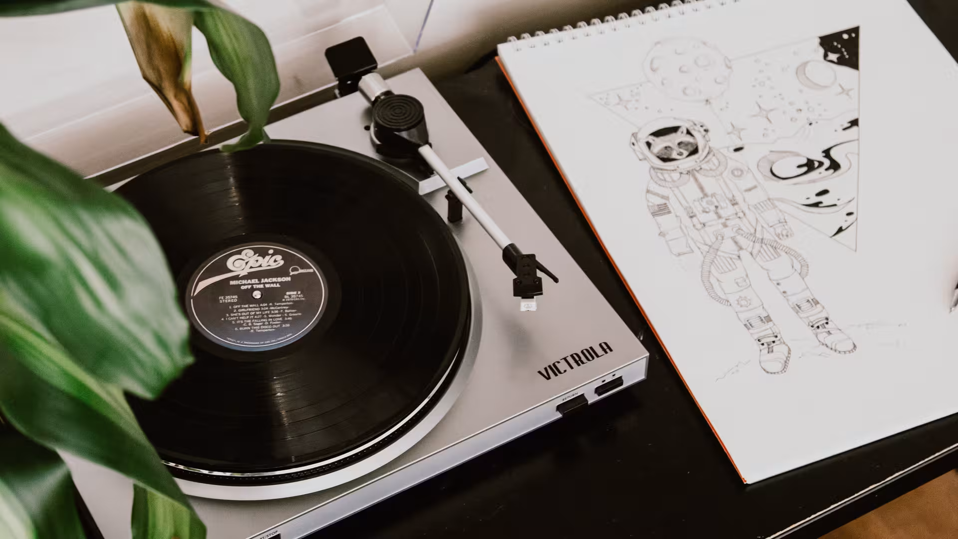 Ein Schallplattenspieler, daneben ein Skizzenblock.