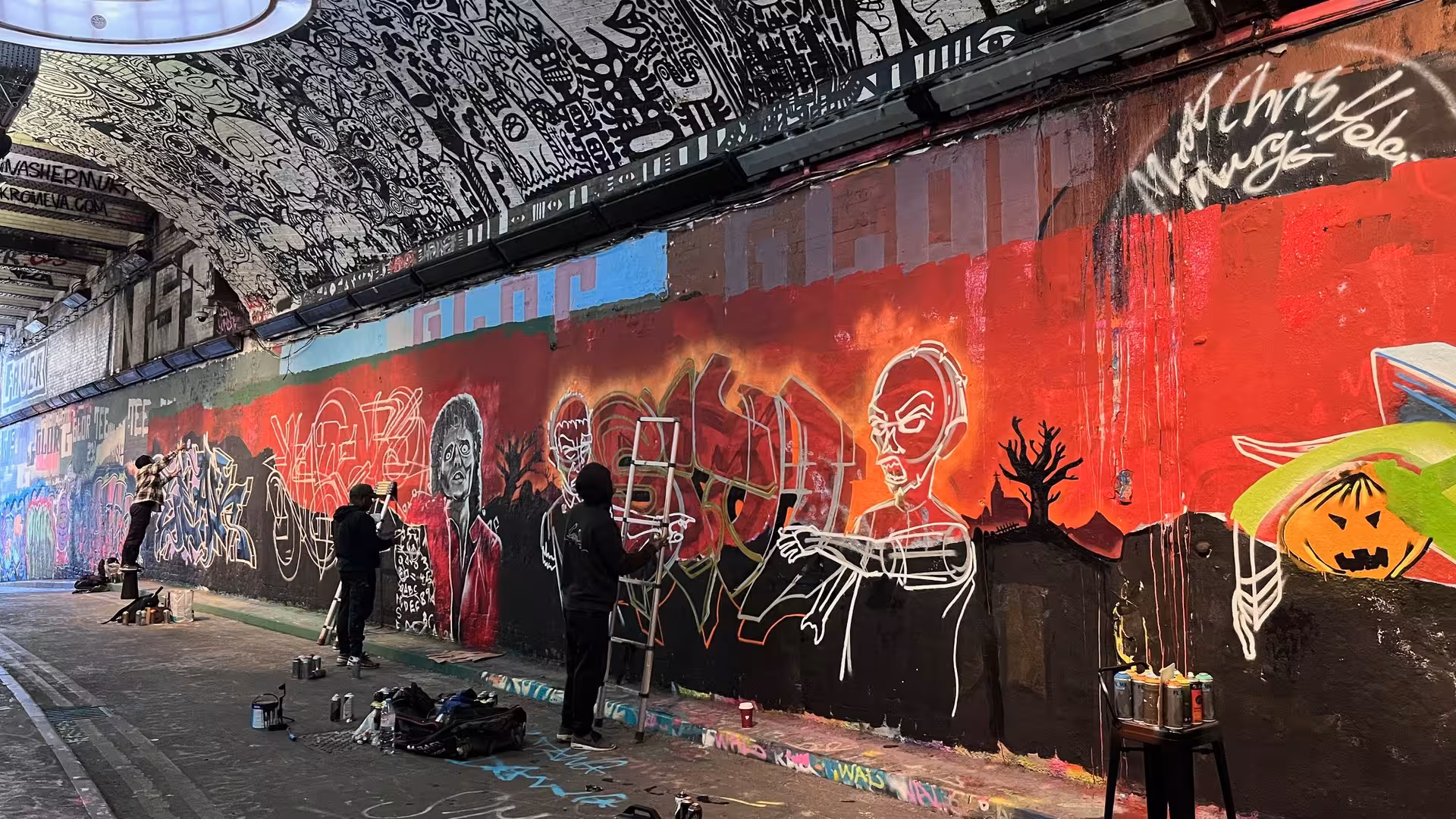 Ein Tunnel, in dem die Wand und die Decke von Graffiti-Künstlern bemalt wird.