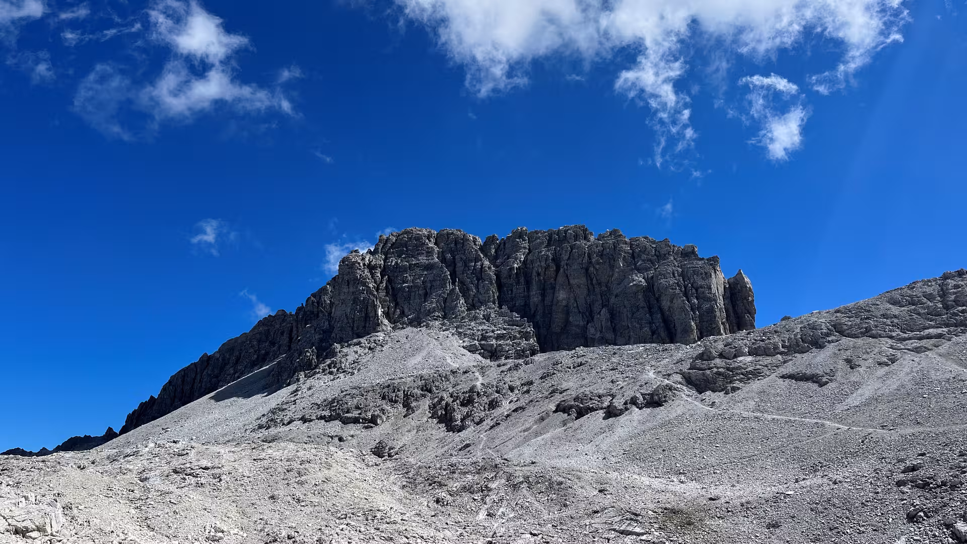 Ein Gebirge von unten fotografiert vor blauem Himmel.