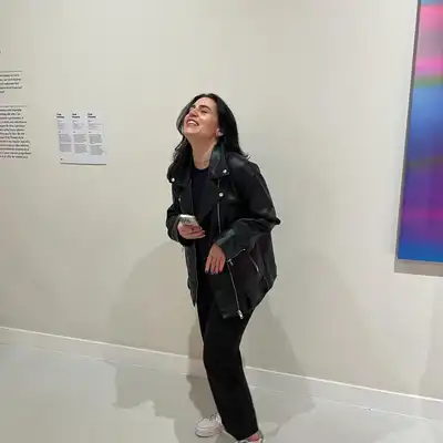 Isabella Kuster, Mitarbeiterin der Castenow GmbH, steht im Museum lachend vor einem Gemälde.