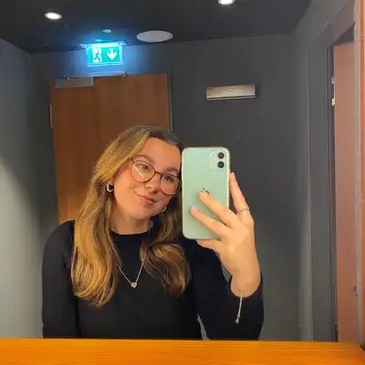 Jasmin Zdzieblowski , Mitabeiterin der Castenow GmbH, macht ein Selfie vor einem Spiegel in einem Flur. Im Hintergrund leuchet ein 