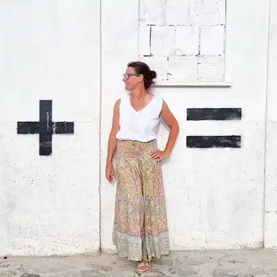 Steffi Daub, Mitarbeiterin von Castenow steht vor einer Wand, die mit + und - markiert ist.