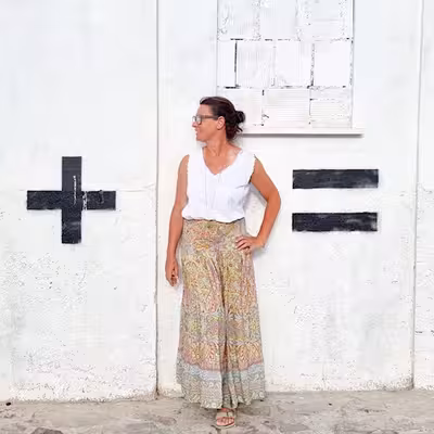 Steffi Daub, Mitarbeiterin von Castenow steht vor einer Wand, die mit + und - markiert ist.